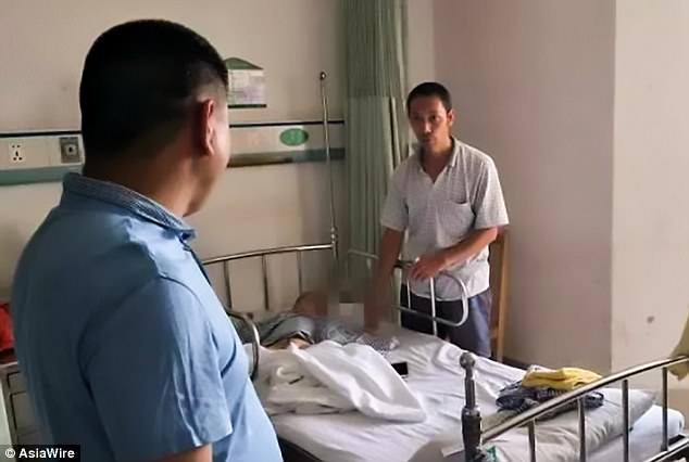 One neighbour is pictured visiting the boy and his father in the hospital in Guangdong