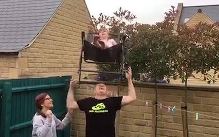Ισορροπεί την κόρη του πάνω σε μια καρέκλα στο κεφάλι του